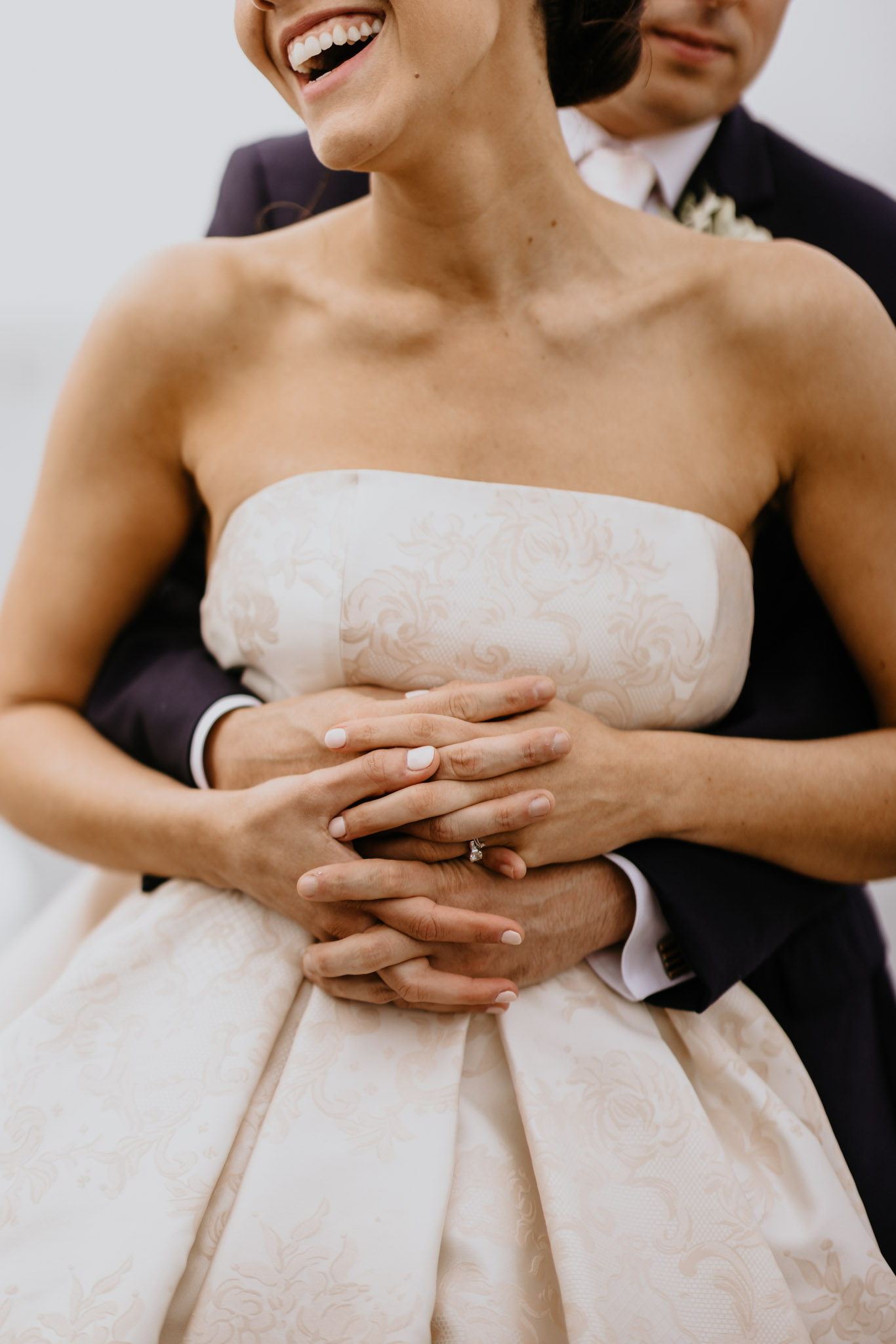 Close up of a couple's hands with wedding rings during a hug